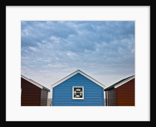 Beach huts in a row against sky by Assaf Frank